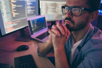 Close-up cropped view portrait of his he nice attractive skilled professional smart focused guy monitoring client's project seo optimization software hardware in dark room workplace station