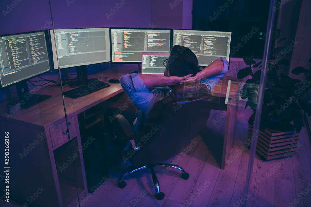 Poster rear back behind view of nice serious skilled genius brunet guy sitting in chair monitoring creating
