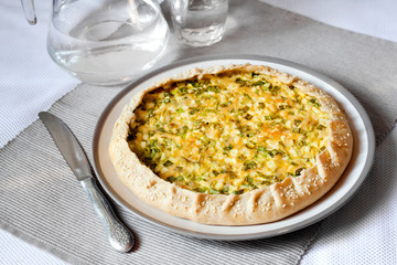 Tart with eggs and green onions on a plate