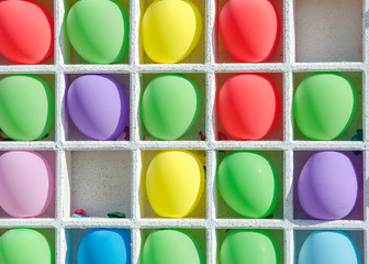  Inflatable multi-colored balls in the wood cells for playing darts.