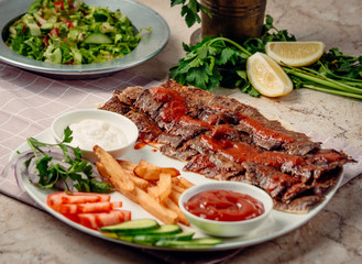 iskender kebab with french fries and vegetables