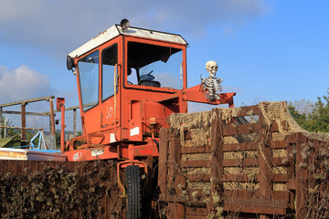 A scary Skeleton sitting on a farm machine to illustrate the concept of Halloween