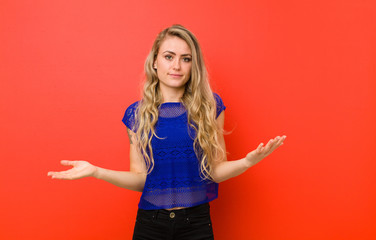 young blonde woman feeling puzzled and confused, unsure about the correct answer or decision,...