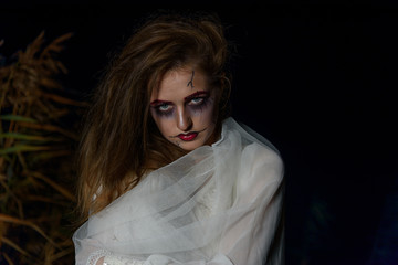 Creepy dead bride at night in a swamp. Halloween scene