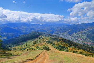 View from the top of the Carpathian Mountains overgrown with forest in autumn colors.