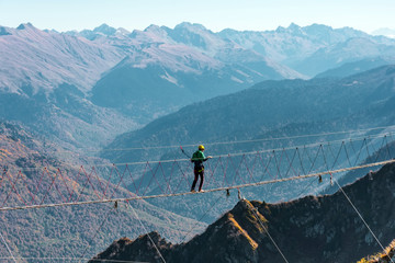 View of the mountain landscape gorge, tourist man walking along an extreme staircase over a precipice.