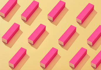 A lot of pink nail buffer block on yellow background. Colorful pattern. Art concept. Art direction....