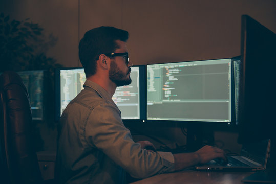 Profile side view of his he nice attractive focused serious skilled qualified brunet guy making outsource optimization hardware software display solution in dark beige room work place station