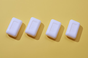 A lot of white soaps on yellow background. Colorful pattern.