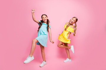 Full body profile photo of two people funny small school ladies models rejoicing summer holidays start wear bright blue yellow dresses isolated pink color background