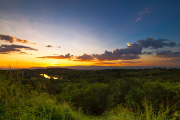 Landscape of local  country during sunset / sunrise over the mountain by see cloud flying in sky and grass flowers in foreground