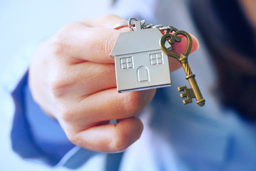 Closeup housing key chain on woman's hand, real estate concept.