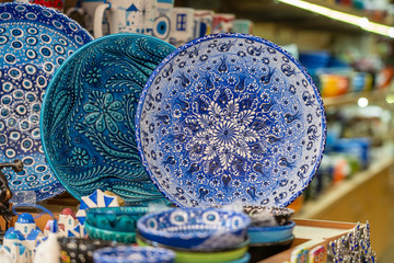 Traditional colorful greek souvenir ceramic plate for sale for tourists in a street shop, closeup. Kos island, Greece.