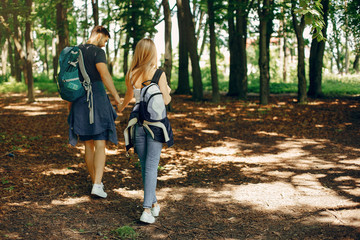 Obraz premium Tourists in a summer forest. Couple with a map.