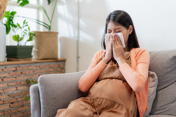 Young Asian pregnant woman have suffering from flu and sneeze, runny nose, stuffy nose and then her...