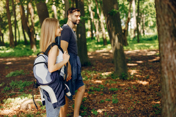 Tourists in a summer forest. Couple with a map.