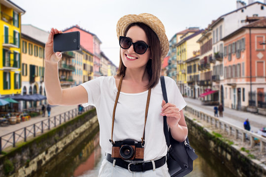 portrait of young beautiful woman tourist taking selfie photo in old italian town