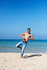 young muscular man resting and posing on the beach. Moves to the beach