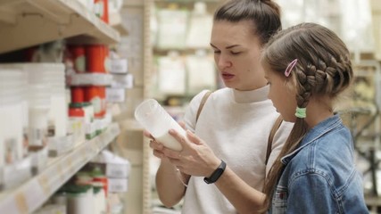 Beautiful woman buying interior items, mother choose products in a supermarket with her children, familyl shopping in a mall