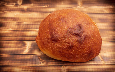Fresh wheat bread on a wooden background