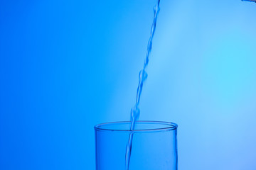 LLenando un vaso de agua, chorro de agua que se introduce en el interior de un vaso