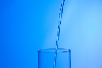 LLenando un vaso de agua, chorro de agua que se introduce en el interior de un vaso