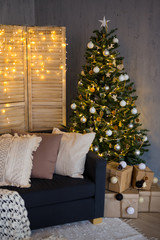 Christmas background - decorated living room with Christmas tree, gift boxes, sofa and folding screen with garlands