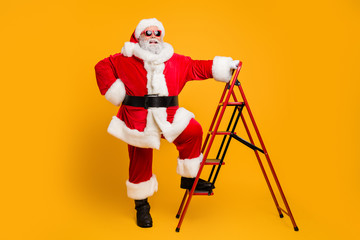 Full size photo of funny funky santa claus in red hat want climb stairs to deliver dream wish gift presents on magic christmas x-mas night isolated over shine color background