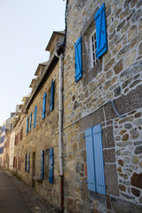 Fototapeta na wymiar Vielle rue de maisons en pierre aux volets bleu en Bretagne