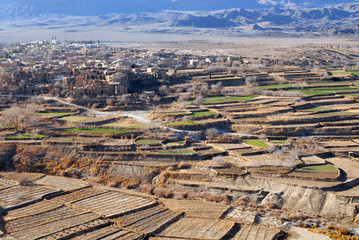 Obraz premium Terrace fields and ruins of medieval adobe mud-brick Kharanaq town. Iran.