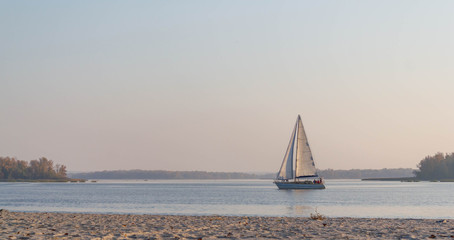 Yacht, Sailboat in the river goes on the water autumn landscape