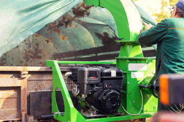 Heavy industrial vaccuum loader loading fallen leaves and junk into truck body. Municipal services cleaning park area removing foliage and debris