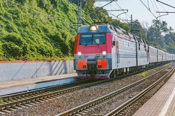Passenger train from Adler moves by Black sea coast.