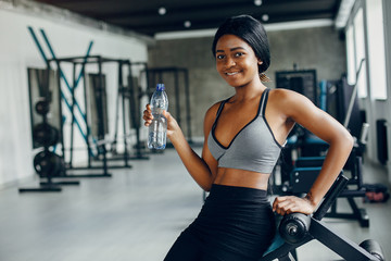 Beautiful black girl in the gym. A woman in a gray top