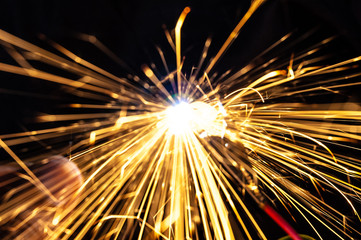 Bright burning sparks fly from the electric short contact