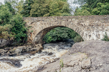 Fototapeta na wymiar A view of a stone bridge in the highlands of Scotland 