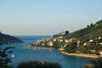 Obraz na płótnie Canvas Panorama from the top of Portovenere, near the Cinque Terre, at sunrise light. The bay with the marina, the fort, the church of San Pietro.