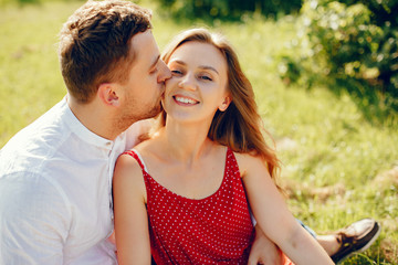 Couple in a field. Girl in a red dress. Man in a white shirt