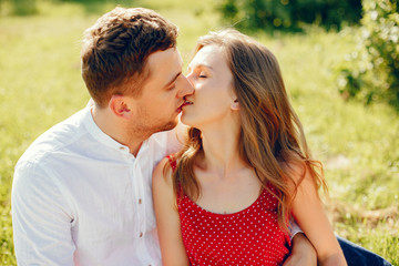 Couple in a field. Girl in a red dress. Man in a white shirt