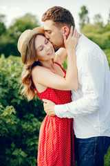 Couple in a field. Girl in a red dress. Man in a white shirt