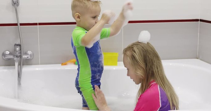 Brother and sister throw foam at each other.