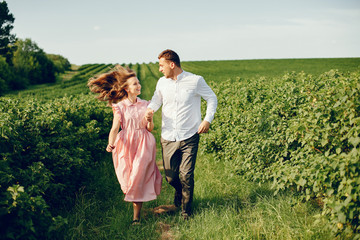 Couple in a field. Girl in a pink dress. Man in a white shirt