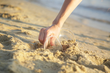 Volunteer woman collecting trash on the beach. Trash-free seas concept. Single-use plastic is a human addiction that is destroying our planet	