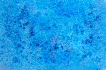 Fototapeta na wymiar Blue watercolor paint background. Blue watercolor paint with pieces of salt top view.