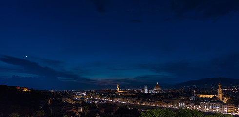 Florence by night - Panorama of Florence, Tuscany, Italy at dusk with the city center and landmarks: Lungarno, cathedral and Palazzo Vecchio (medieval city hall) and Boboli Gardens on the far left und