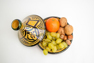 Maghreb terracotta pot, tajine or tagine, full of autumn fruit, isolated on a white background, view from above.