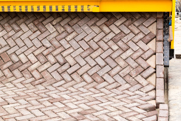 Paving machine rolling out carpet of bricks