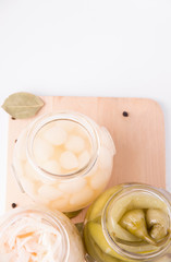 Fermented onions, cabbage and peppers in a jar on a white background