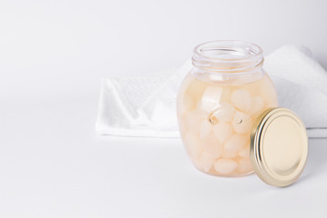Fermented onions in a tank on a white background. copy space