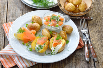 Leckere Baby-Ofenkartoffeln mit frischem Kräuterquark und Räucherlachs serviert – Small potatoes fresh from the oven served with herb curd and smoked salmon 